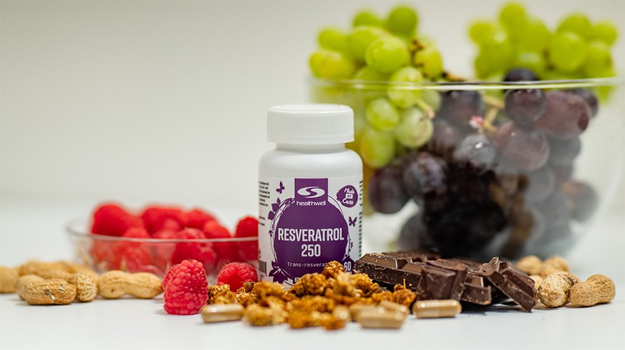 Billede af en krukke med resveratrol sammen med hindbr, jordndder, vindruer, morbr og chokolade.